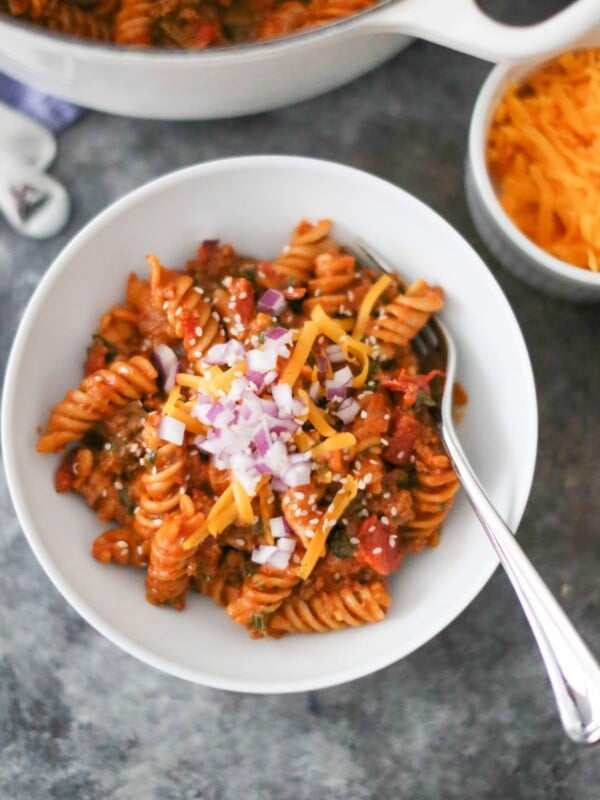 Bowl of one-pot cheeseburger pasta with toppings.