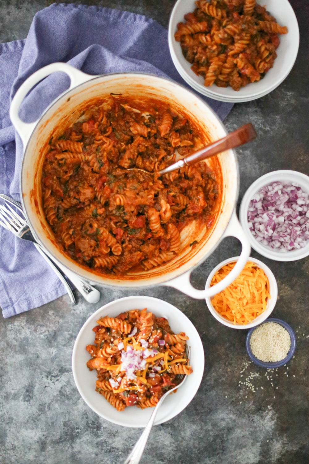One pot cheeseburger pasta in the pot with two plated servings.