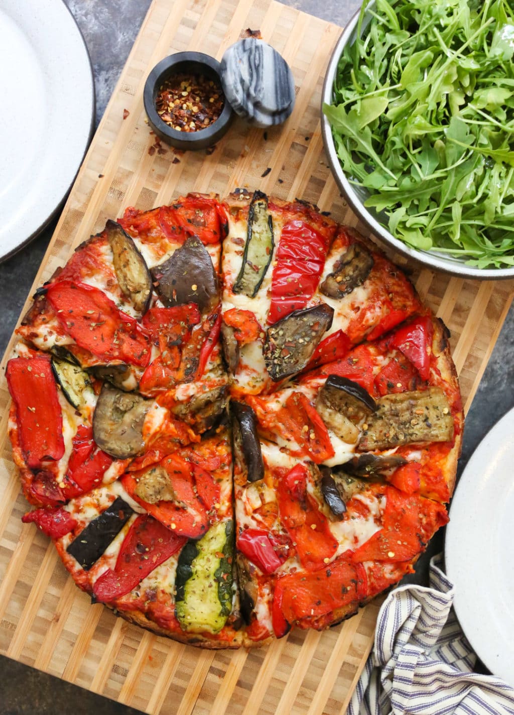 Grilled Vegetable Flatbread sliced with a side salad and serving plates.